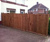Wooden posts and feather edge fence panels.